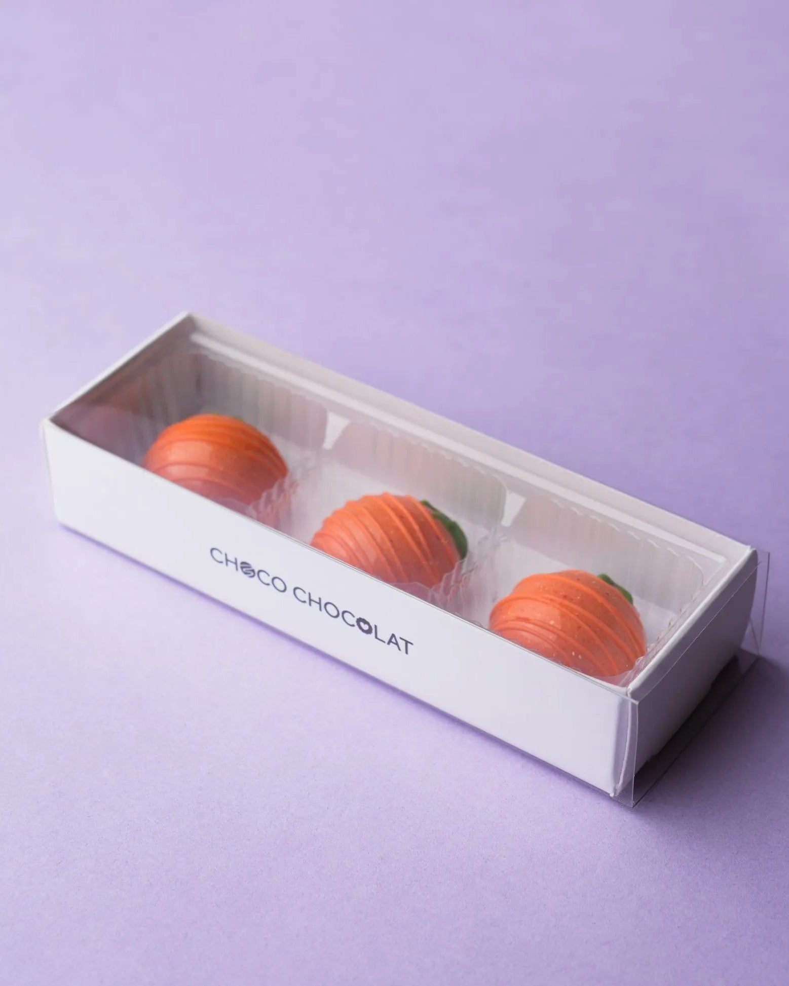 Une boîte contenant trois carottes en chocolat.