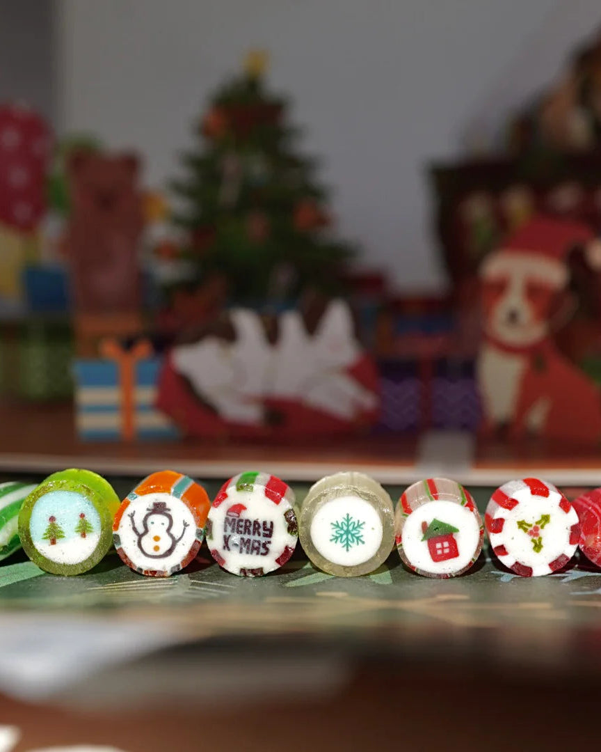 Des bonbons de Candy Labs sont présentés côte-à-côte sur une table dans un décor de Noël.