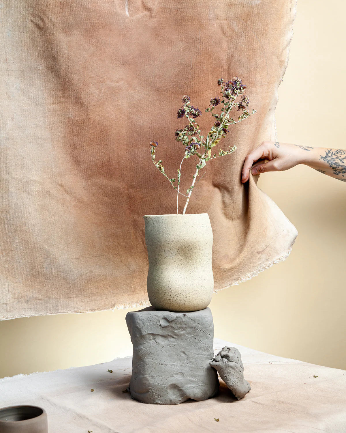 Une carafe de couleur beige moucheté de l'entreprise Dompierre est sur une table dans un décor terreux.