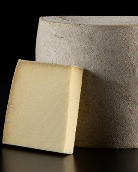 Une meule de fromage Blackburn sur un fond noir de la fromagerie Blackburn.
