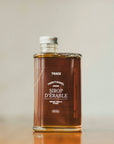 Une bouteille de sirop d'érable pur ambré de l'entreprise Trace - Érable & Territoire.